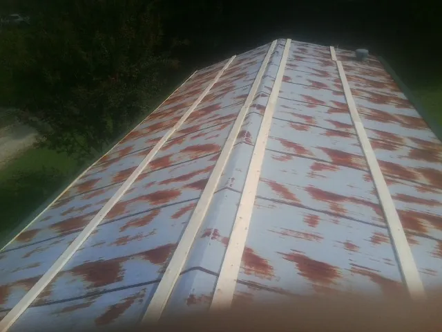 Rusted metal roof panels with new wood purlins before replacement — Storm Damage Roof Repair in Humeston by Roofing Brothers