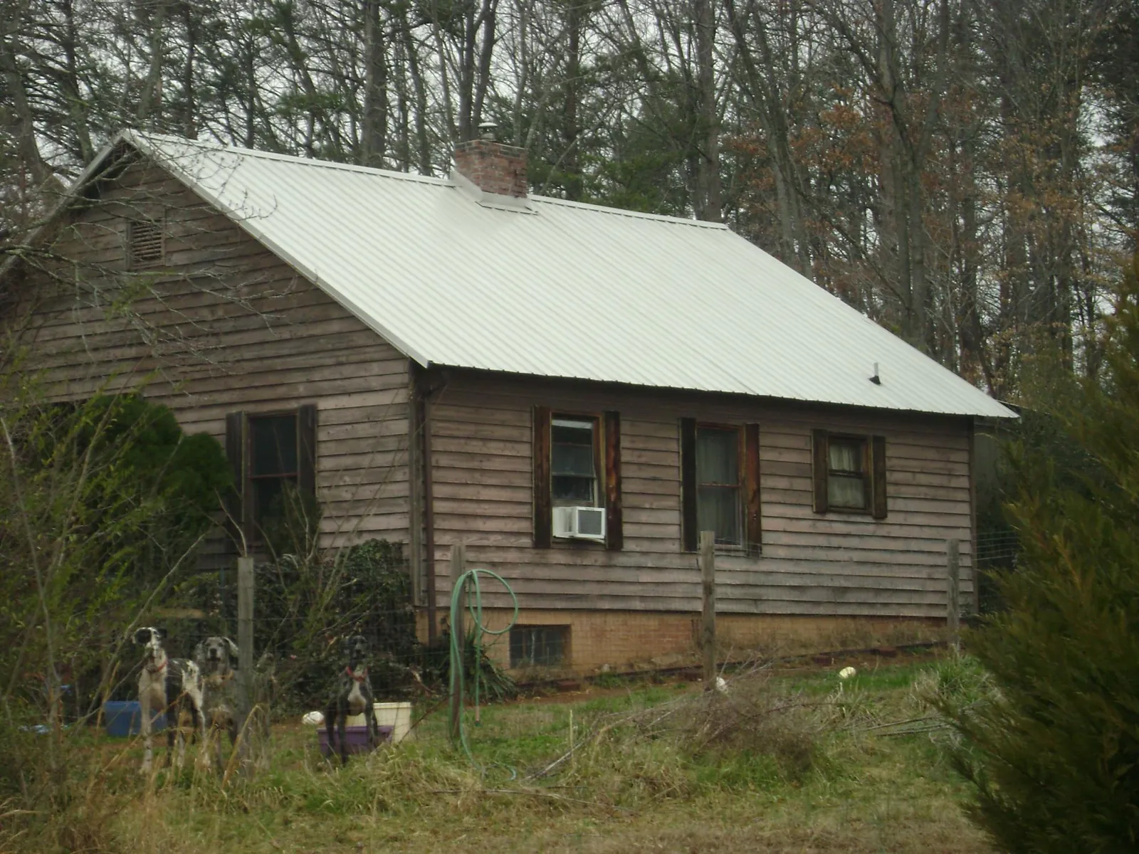 White metal roof on an old wood sided farmhouse, from a Asphalt Shingle Roof Repair job in Humeston